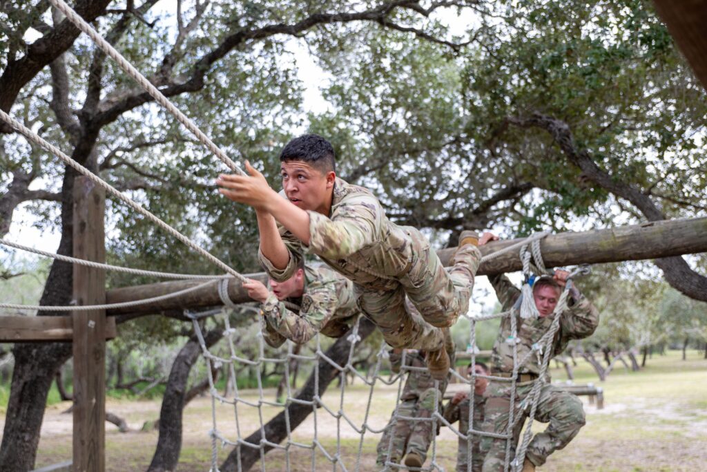 Corp of cadet crawling on a rope.